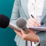 Female reporter taking notes at press conference